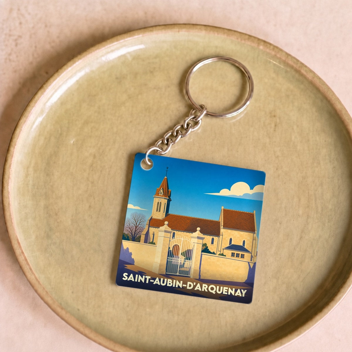 Porte-clés souvenir de la ville de Saint-Aubin-d'Arquenay avec une illustration stylisée.