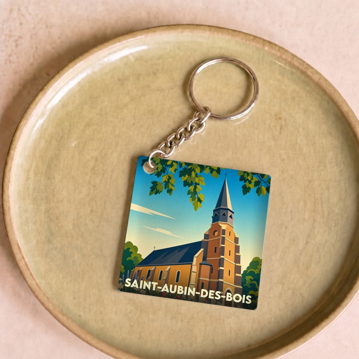 Porte-clés souvenir de la ville de Saint-Aubin-des-Bois avec une illustration stylisée de son église.