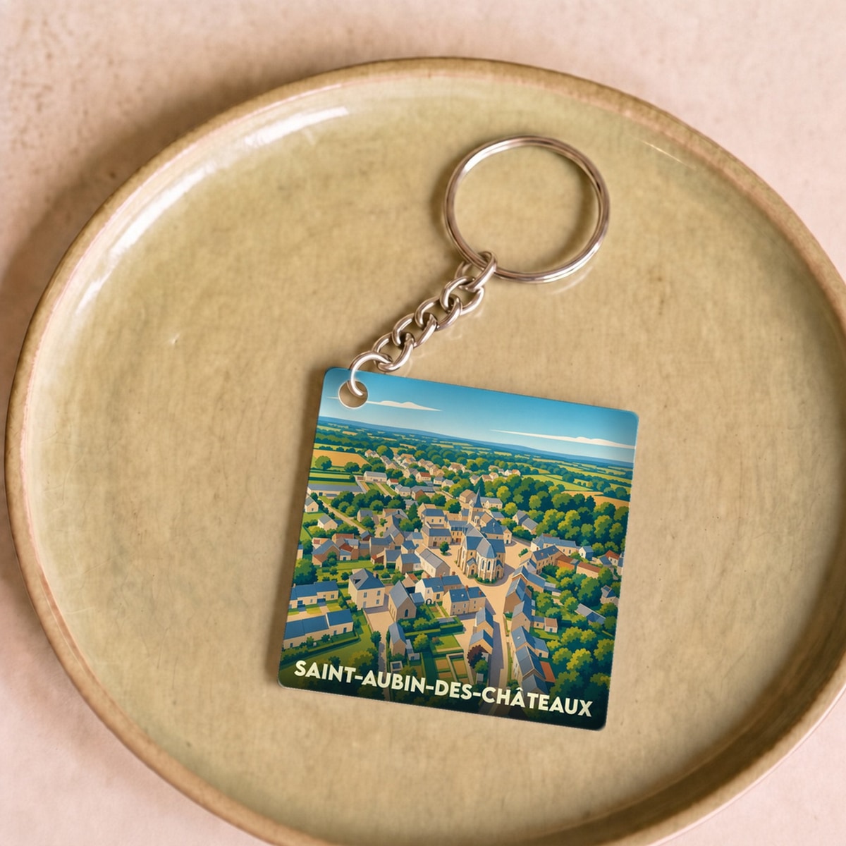 Porte-clés souvenir de la ville de Saint-Aubin-des-Châteaux avec une illustration stylisée vue du ciel.