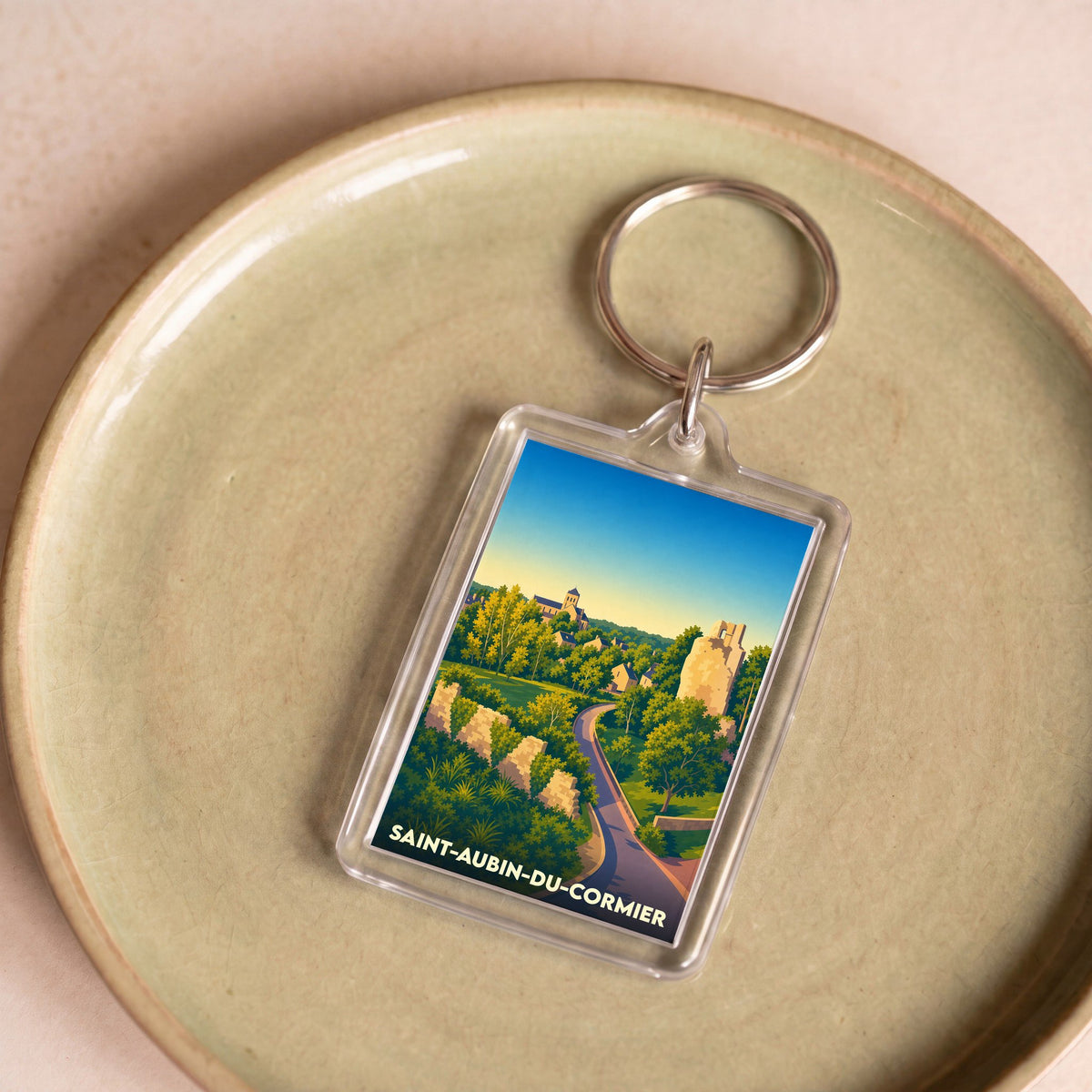 Porte-clés souvenir de la ville de Saint-Aubin-du-Cormier avec une illustration stylisée.