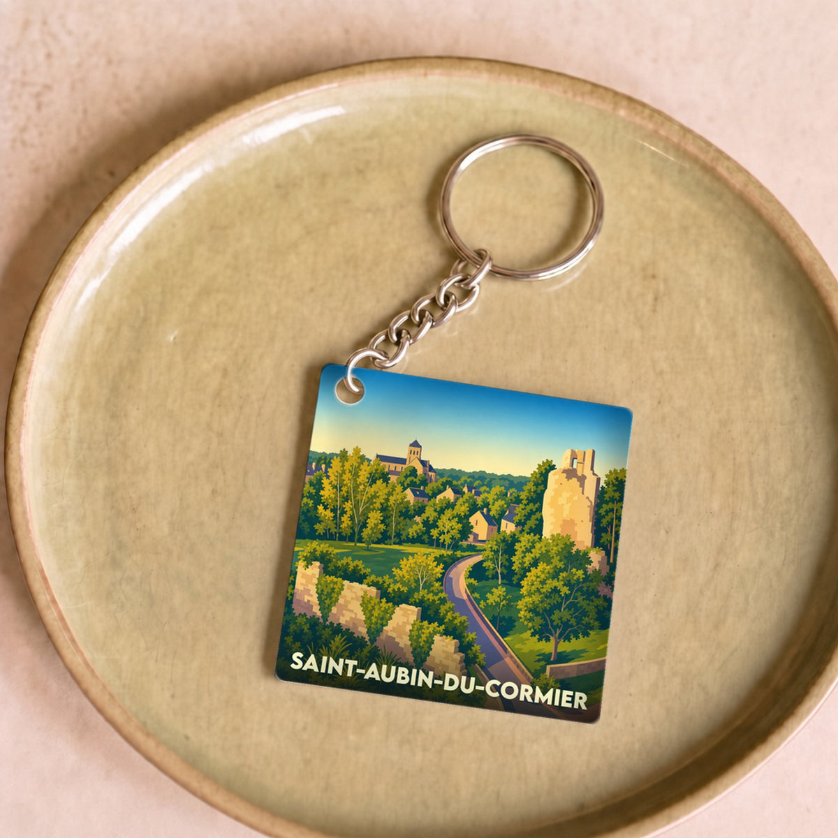 Porte-clés souvenir de la ville de Saint-Aubin-du-Cormier avec une illustration stylisée.