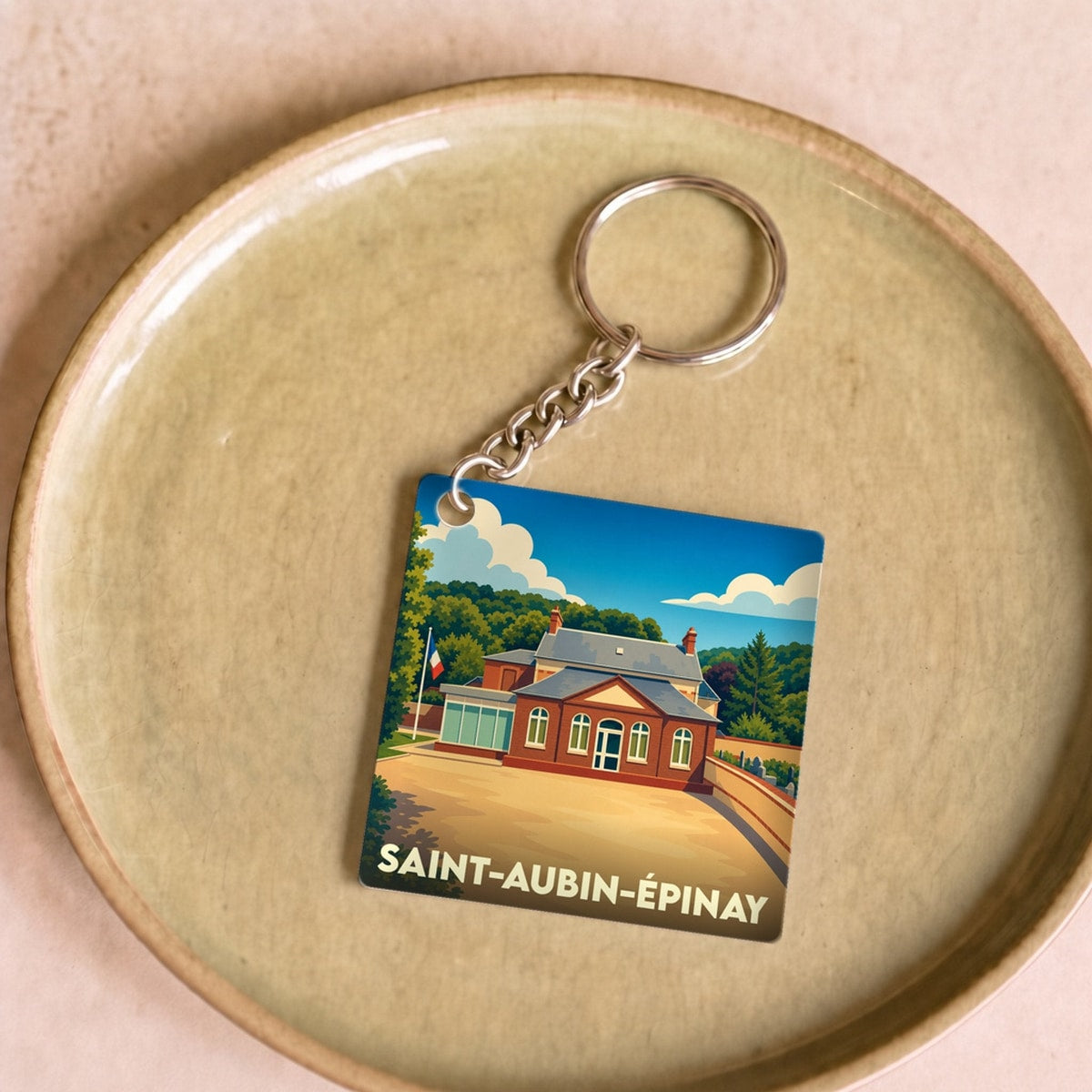 Porte-clés souvenir de la ville de Saint-Aubin-Épinay avec une illustration stylisée.
