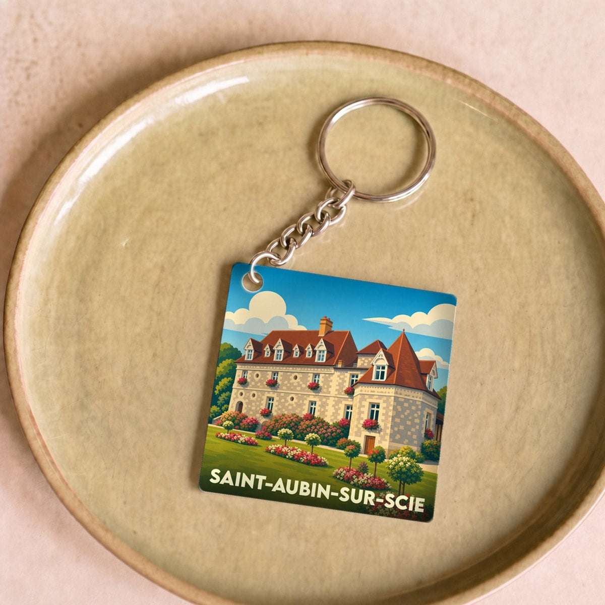 Porte-clés souvenir de la ville de Saint-Aubin-sur-Scie avec une illustration stylisée d'un château fleuri.