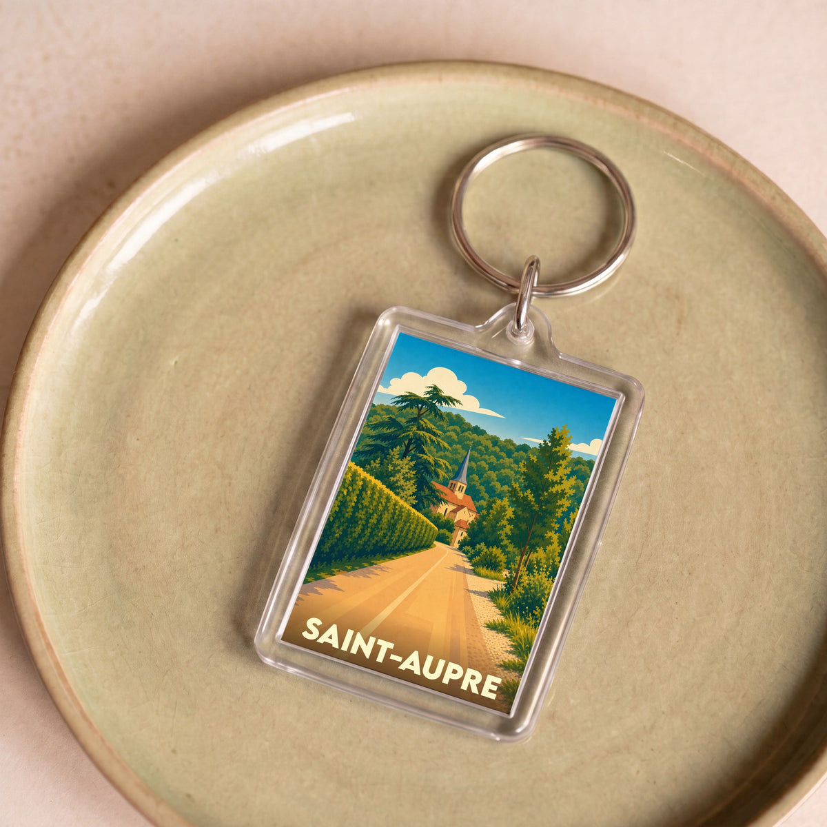 Porte-clés souvenir de la ville de Saint-Aupre avec une illustration stylisée d'un paysage local.