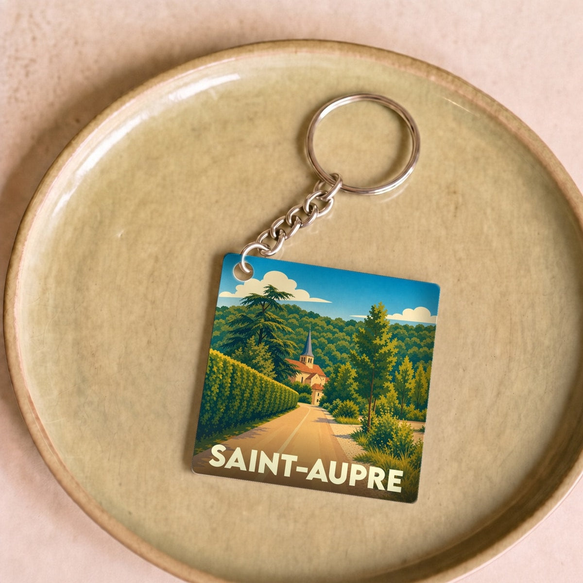 Porte-clés souvenir de la ville de Saint-Aupre avec une illustration stylisée d'un paysage local.
