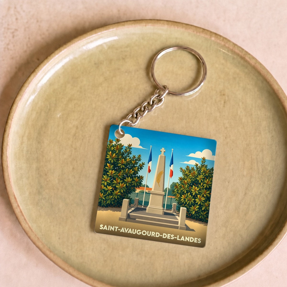 Porte-clés souvenir de la ville de Saint-Avaugourd-des-Landes avec une illustration stylisée de son monument aux morts.