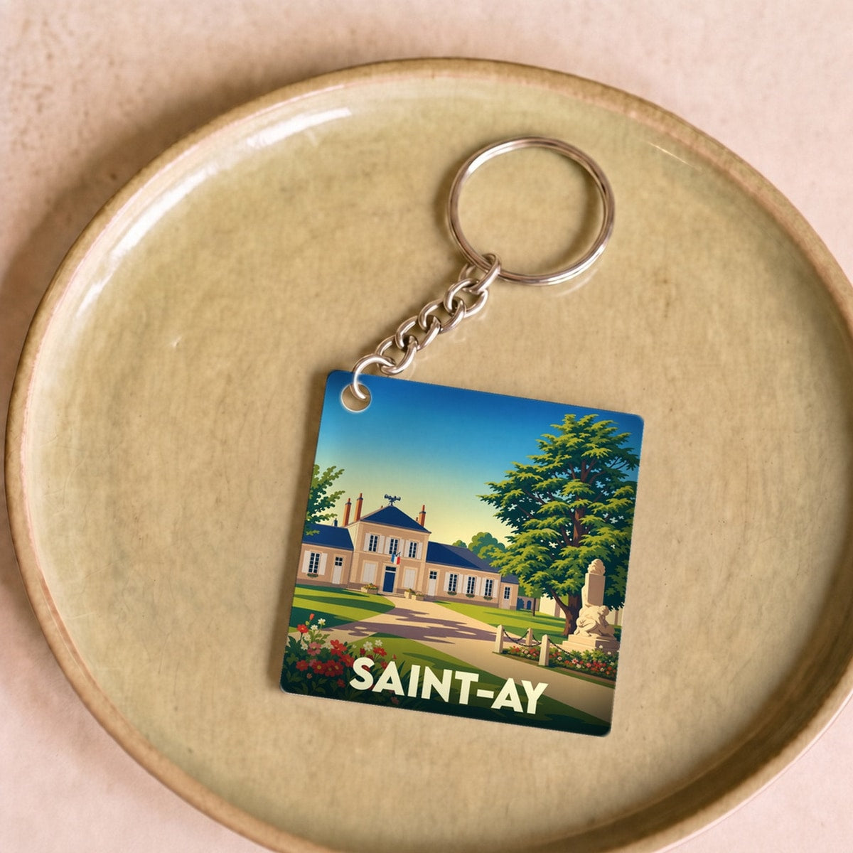 Porte-clés souvenir de la ville de Saint-Ay avec une illustration stylisée de son patrimoine.