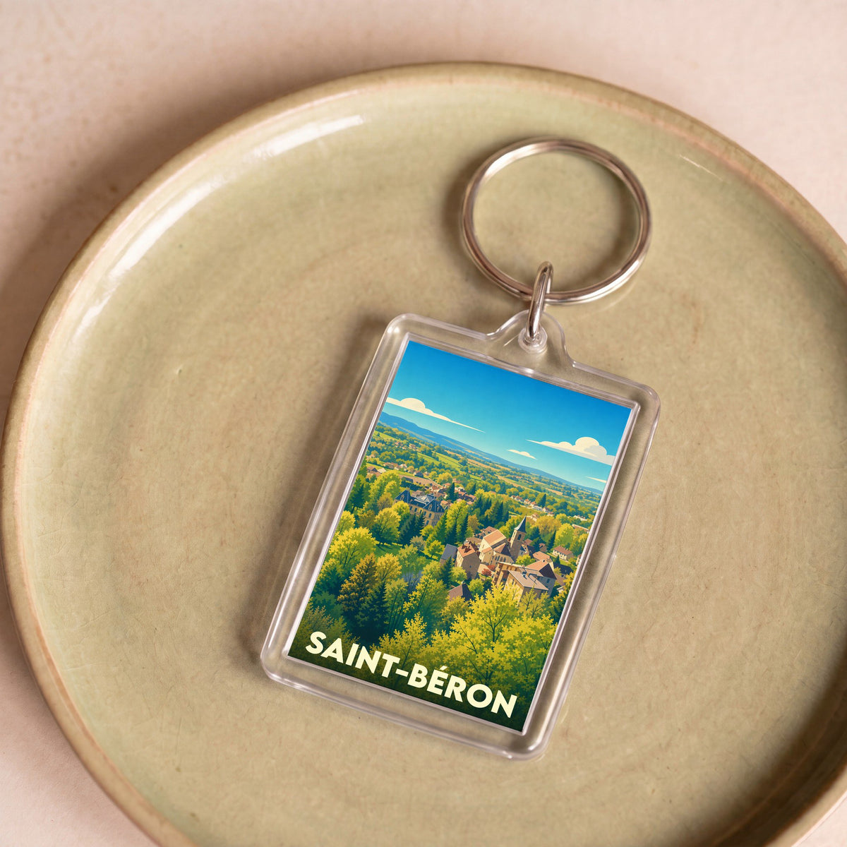 Porte-clés souvenir de la ville de Saint-Béron avec une illustration stylisée de son paysage verdoyant.