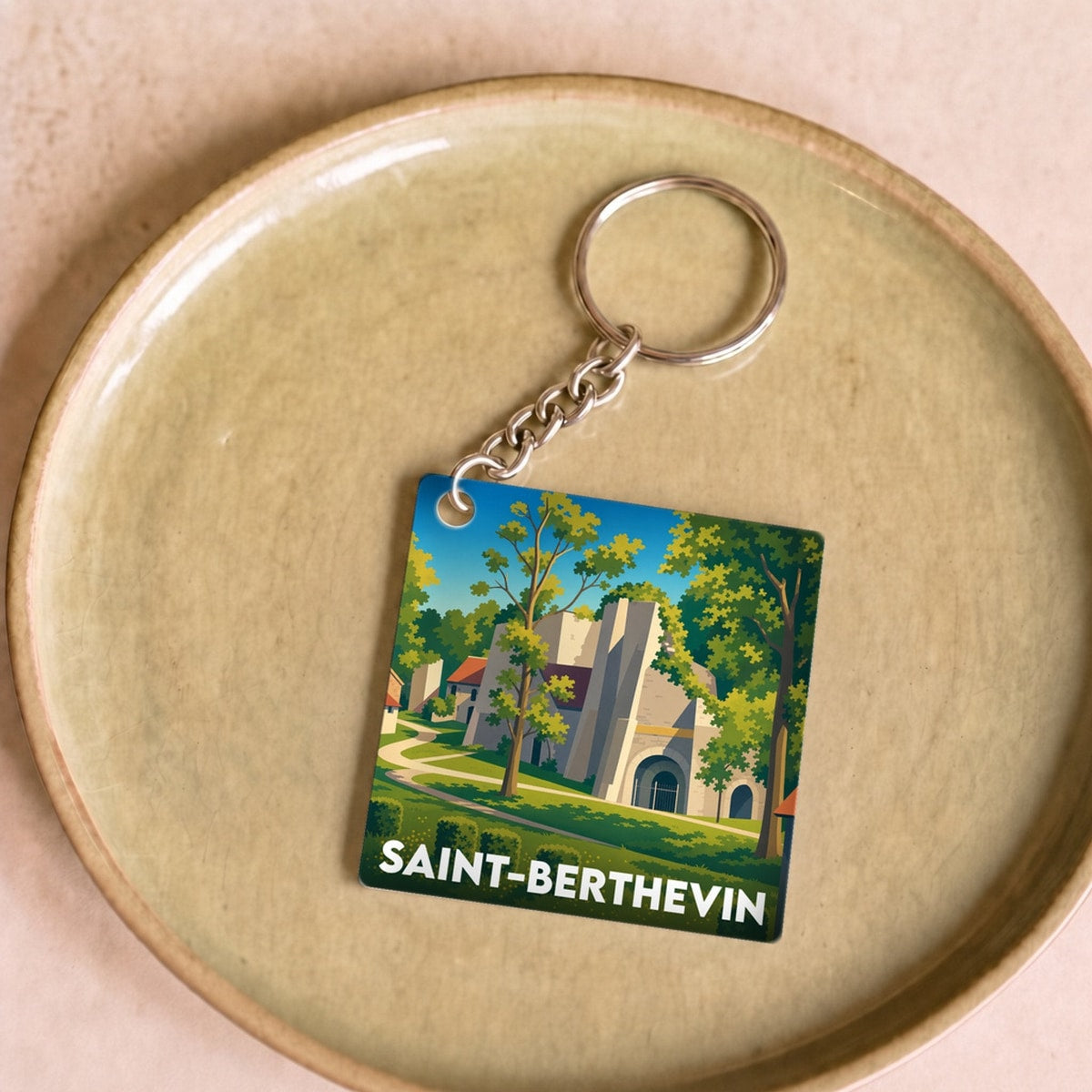 Porte-clés souvenir de la ville de Saint-Berthevin avec une illustration stylisée.