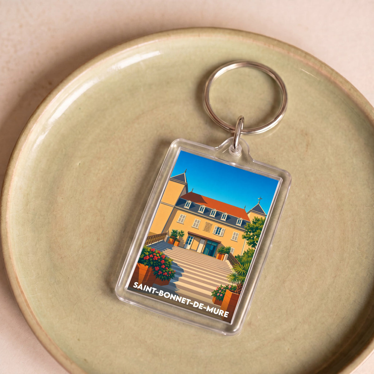 Porte-clés souvenir de la ville de Saint-Bonnet-de-Mure avec une illustration stylisée.