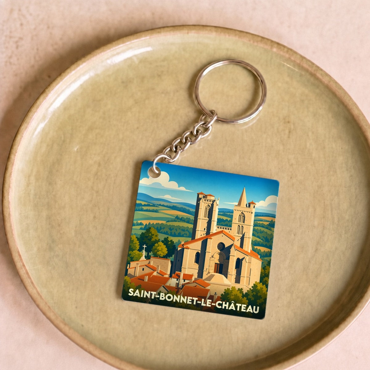 Porte-clés souvenir de la ville de Saint-Bonnet-le-Château avec une illustration stylisée de sa collégiale.