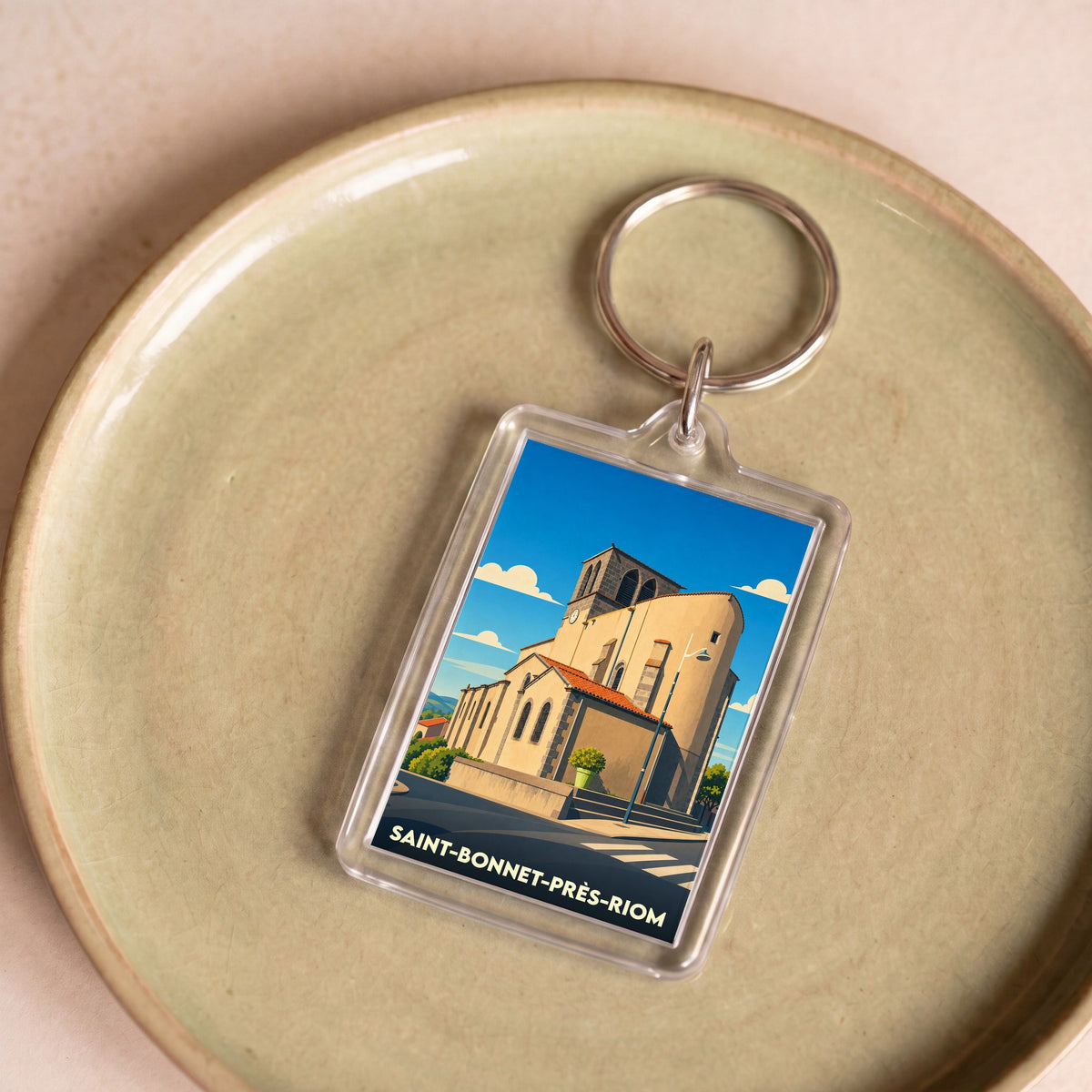 Porte-clés souvenir de la ville de Saint-Bonnet-près-Riom avec une illustration stylisée de son église.
