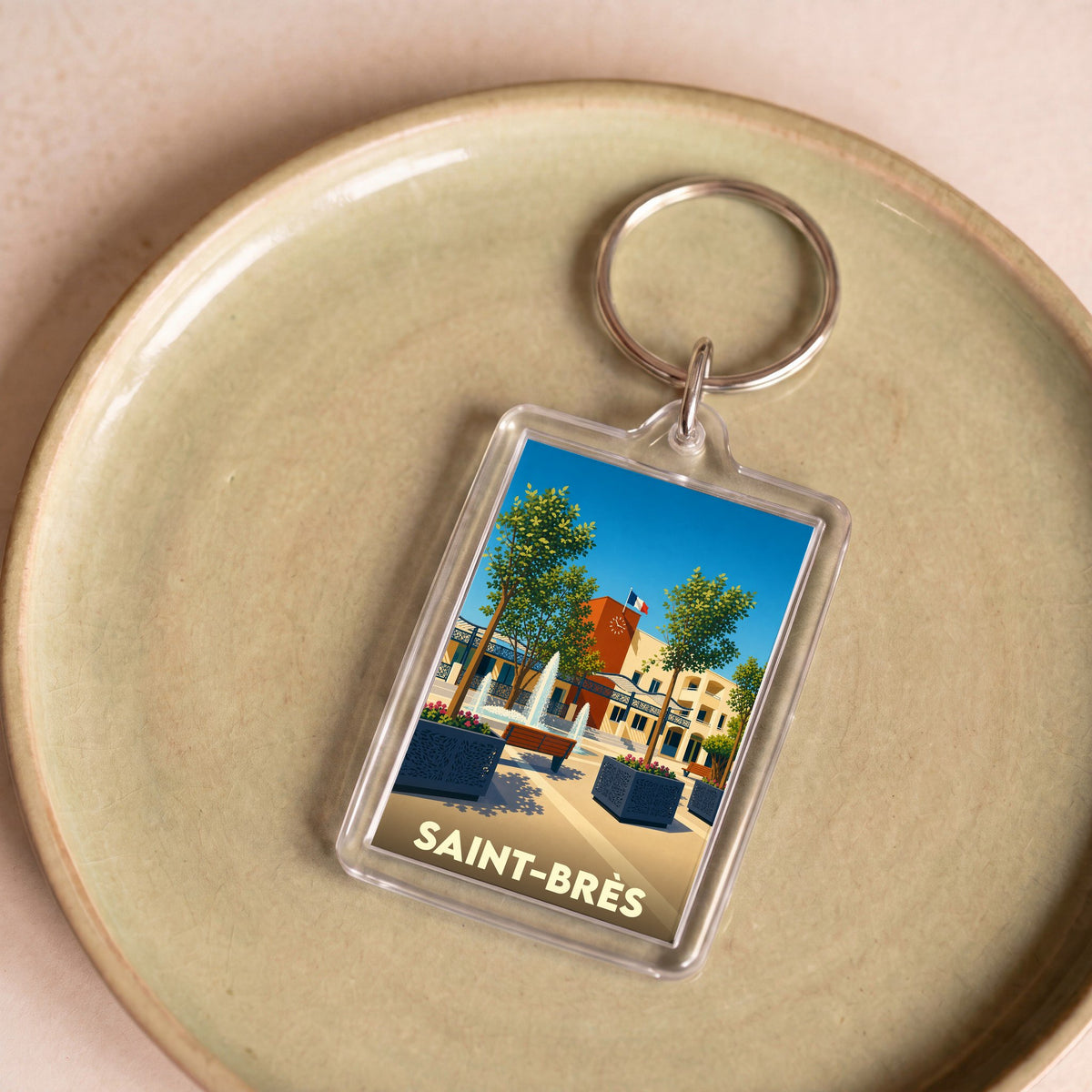 Porte-clés souvenir de la ville de Saint-Brès avec une illustration stylisée.