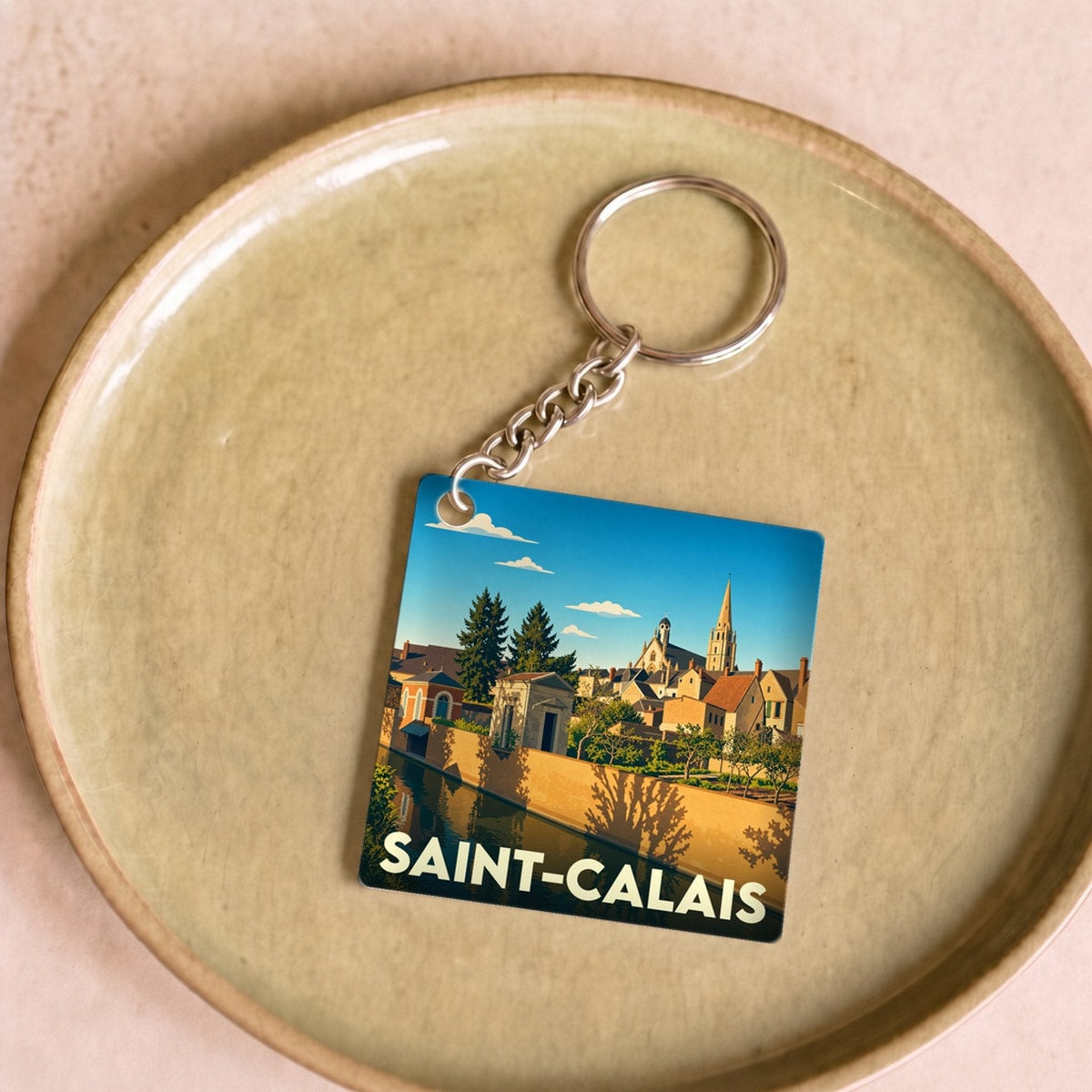 Porte-clés souvenir de la ville de Saint-Calais avec une illustration stylisée.