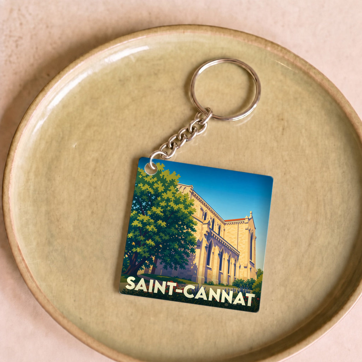 Porte-clés souvenir de la ville de Saint-Cannat avec une illustration stylisée de son église.