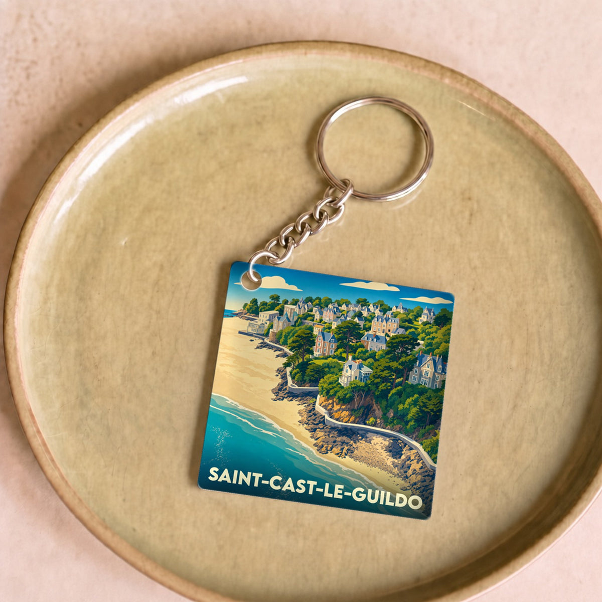 Porte-clés souvenir de la ville de Saint-Cast-le-Guildo avec une illustration stylisée du littoral.
