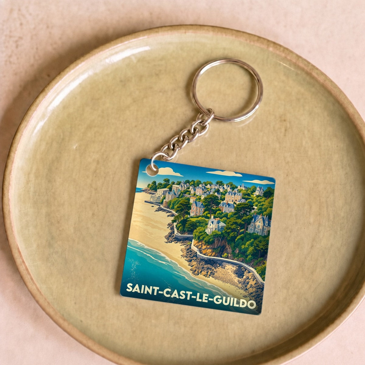 Porte-clés souvenir de la ville de Saint-Cast-le-Guildo avec une illustration stylisée du littoral.