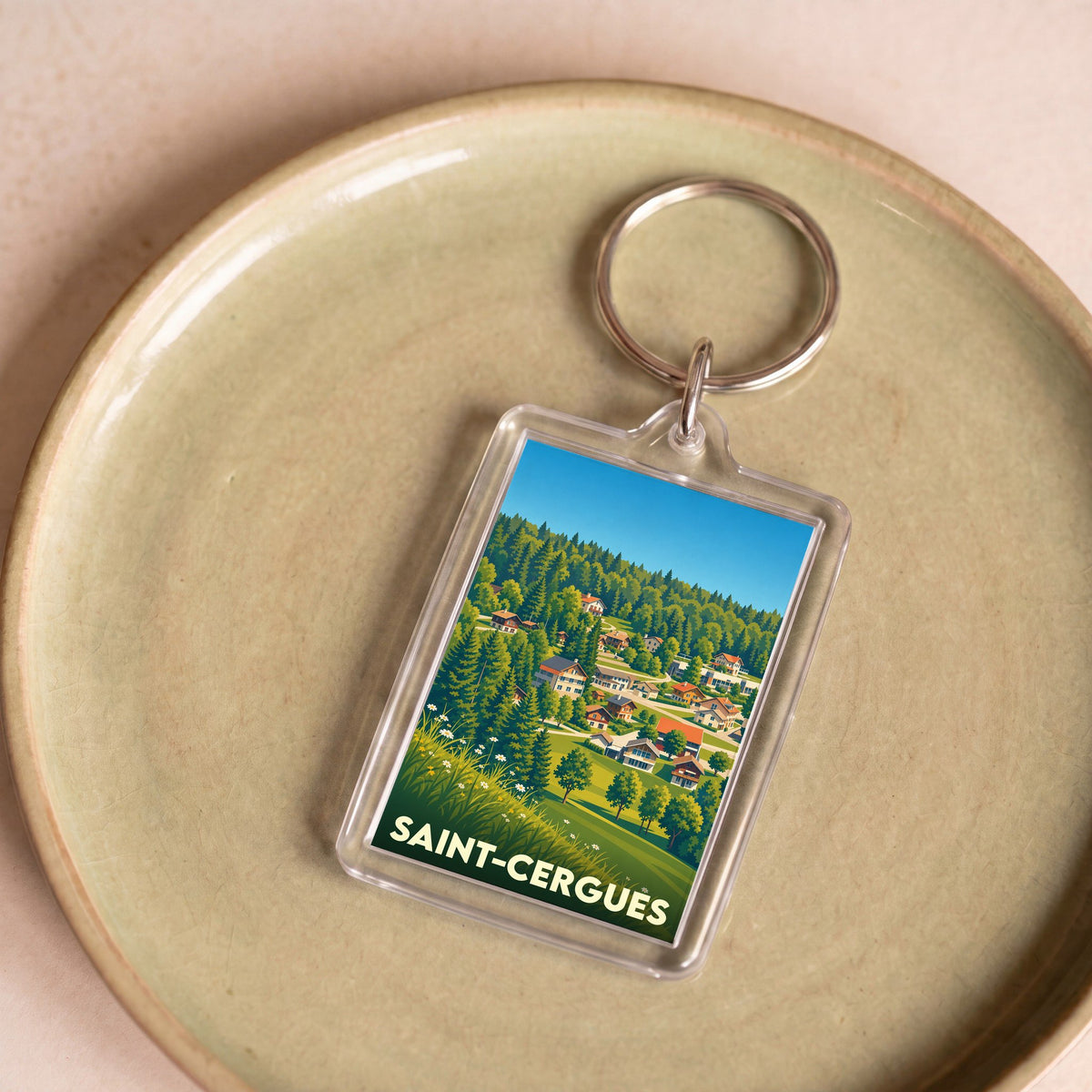 Porte-clés souvenir de la ville de Saint-Cergues avec une illustration stylisée de son paysage vallonné.