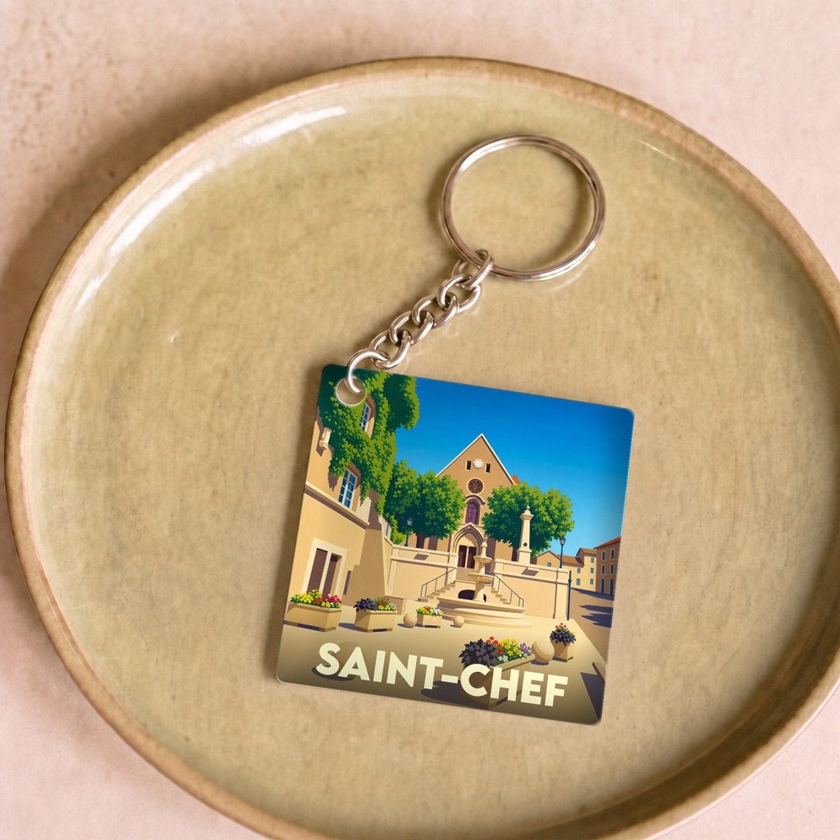 Porte-clés souvenir de la ville de Saint-Chef avec une illustration stylisée.