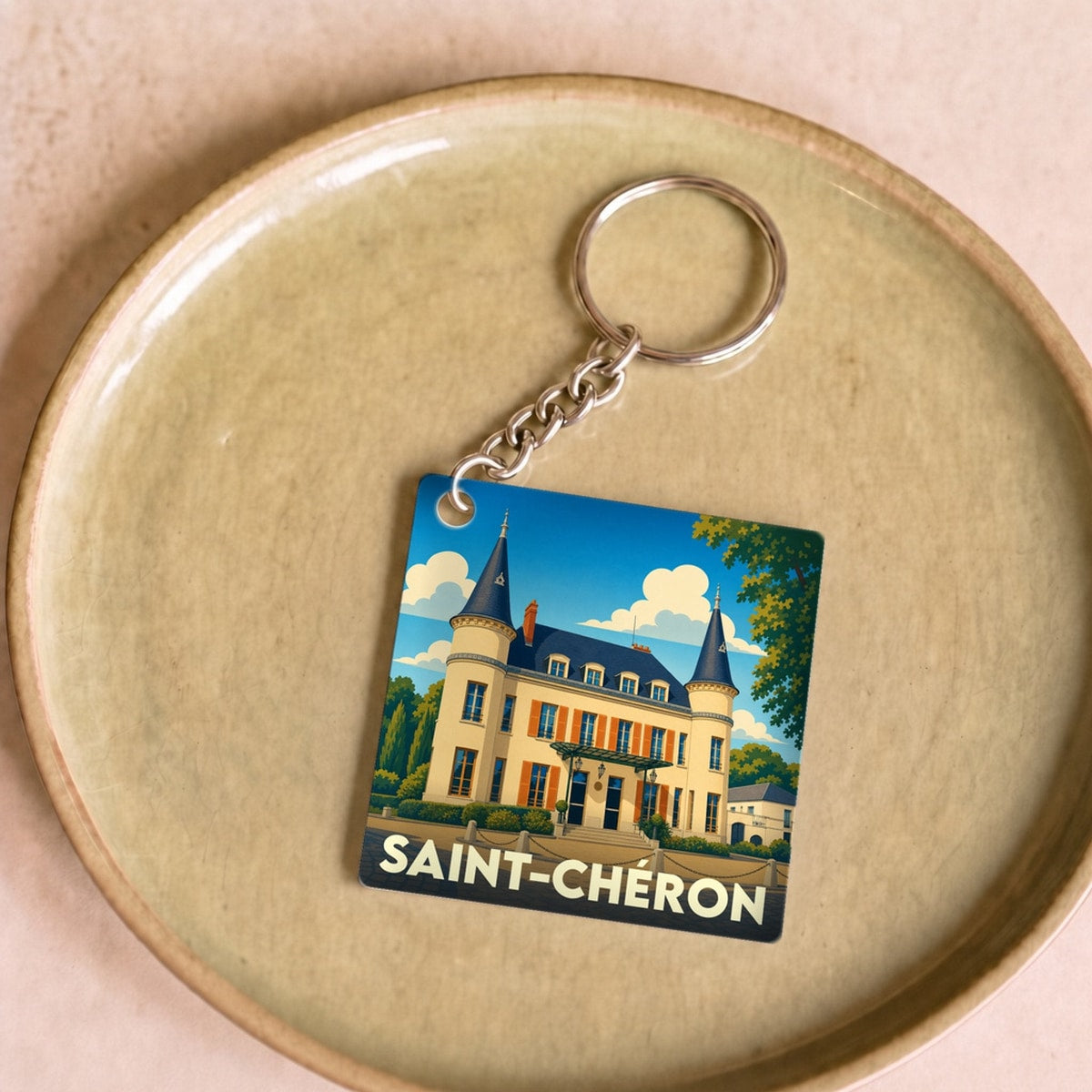 Porte-clés souvenir de la ville de Saint-Chéron avec une illustration stylisée d'un château.