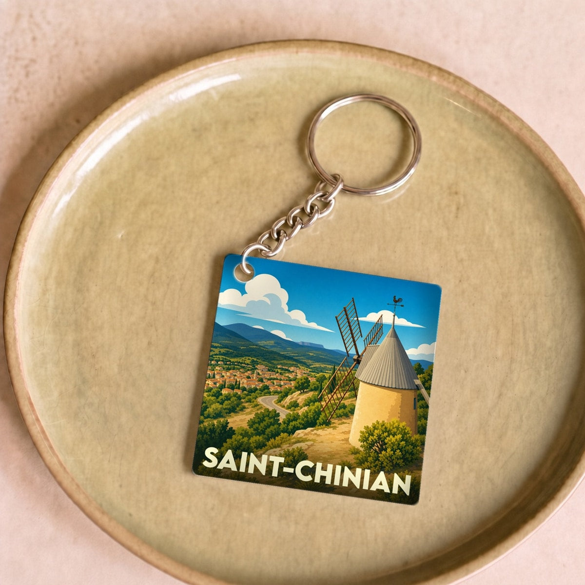 Porte-clés souvenir de la ville de Saint-Chinian avec une illustration stylisée d'un moulin.