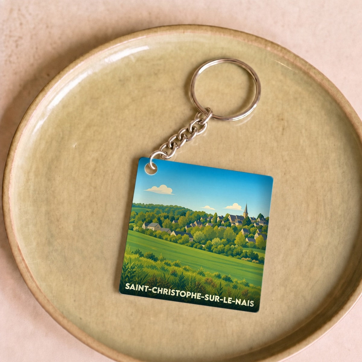 Porte-clés souvenir de la ville de Saint-Christophe-sur-le-Nais avec une illustration paysagère stylisée.