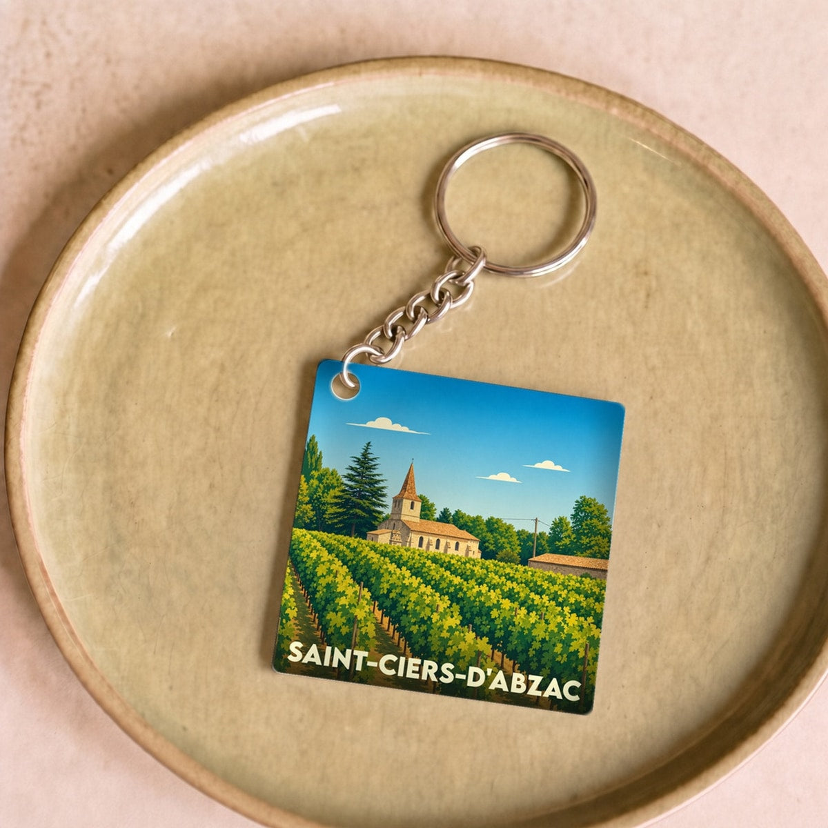Porte-clés souvenir de la ville de Saint-Ciers-d'Abzac avec une illustration stylisée de son église et de ses vignobles.