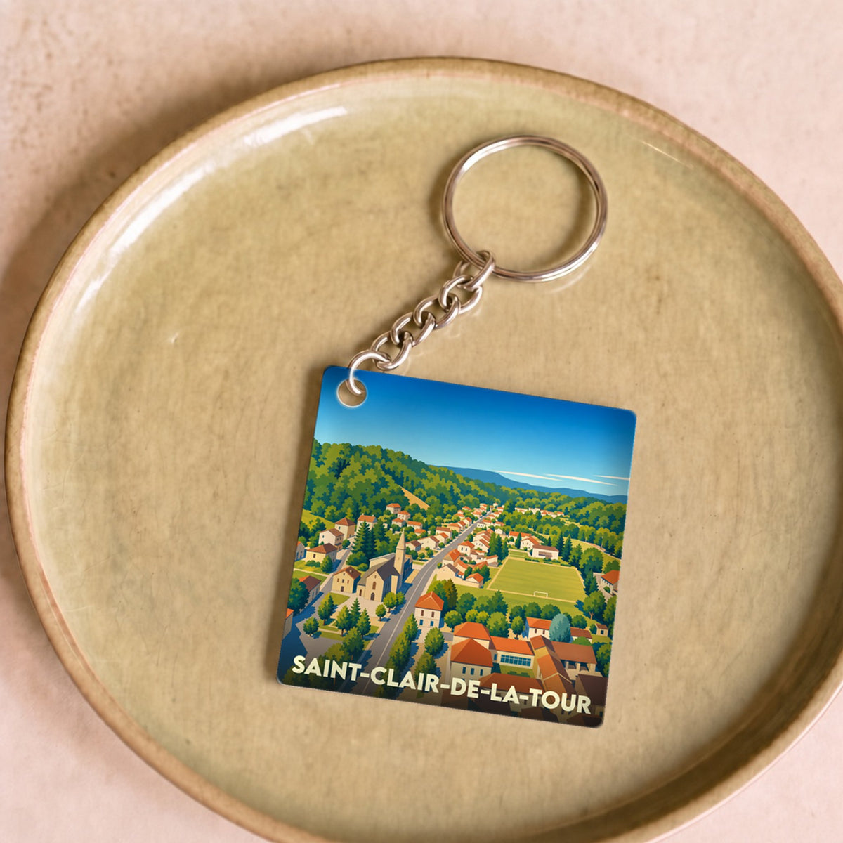 Porte-clés souvenir de la ville de Saint-Clair-de-la-Tour avec une illustration stylisée.
