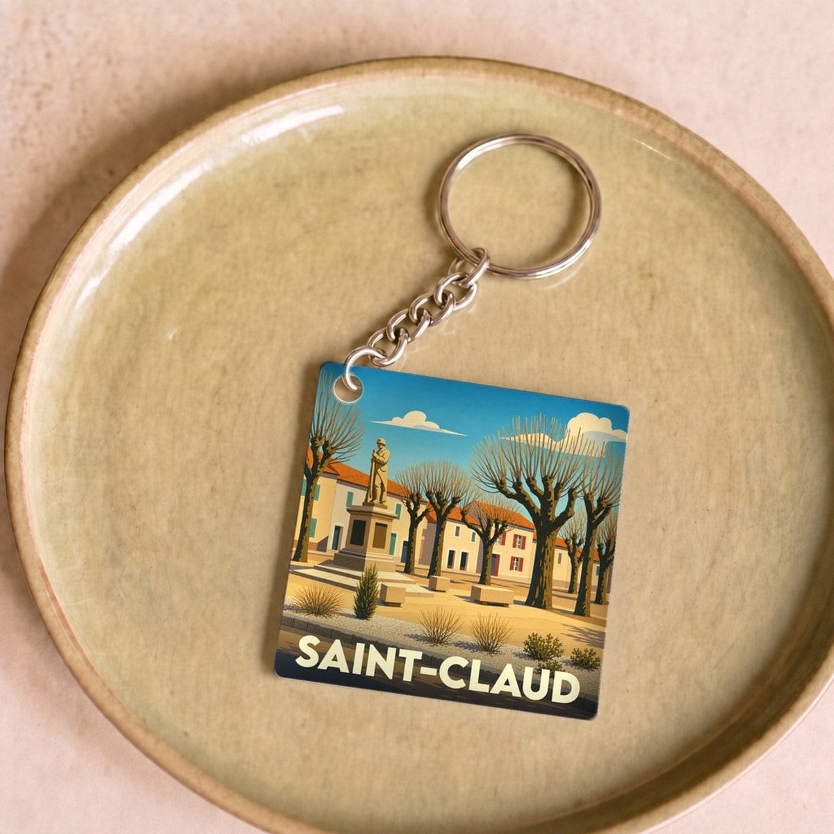 Porte-clés souvenir de la ville de Saint-Claud avec une illustration stylisée.