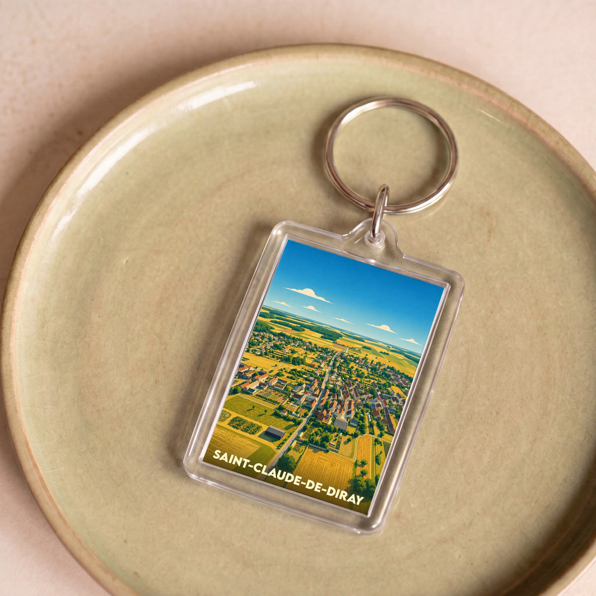 Porte-clés souvenir de la ville de Saint-Claude-de-Diray avec une illustration stylisée vue du ciel.