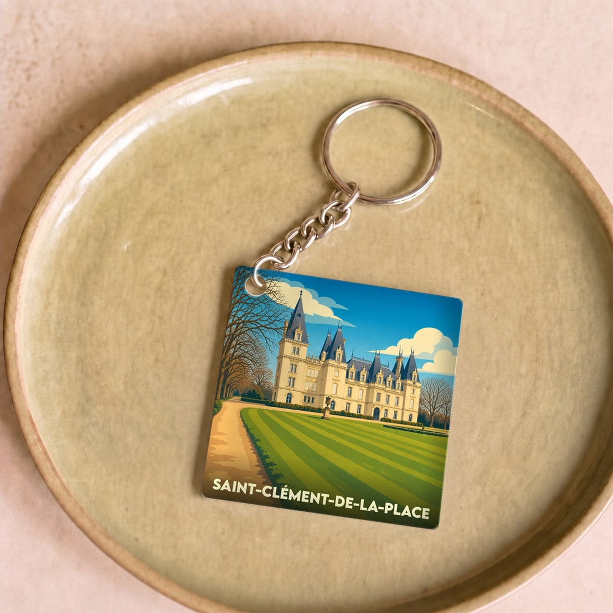 Porte-clés souvenir de la ville de Saint-Clément-de-la-Place avec une illustration stylisée de son château.