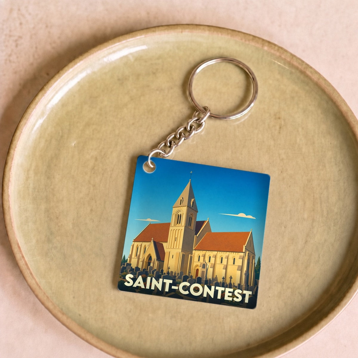 Porte-clés souvenir de la ville de Saint-Contest avec une illustration stylisée de son église.