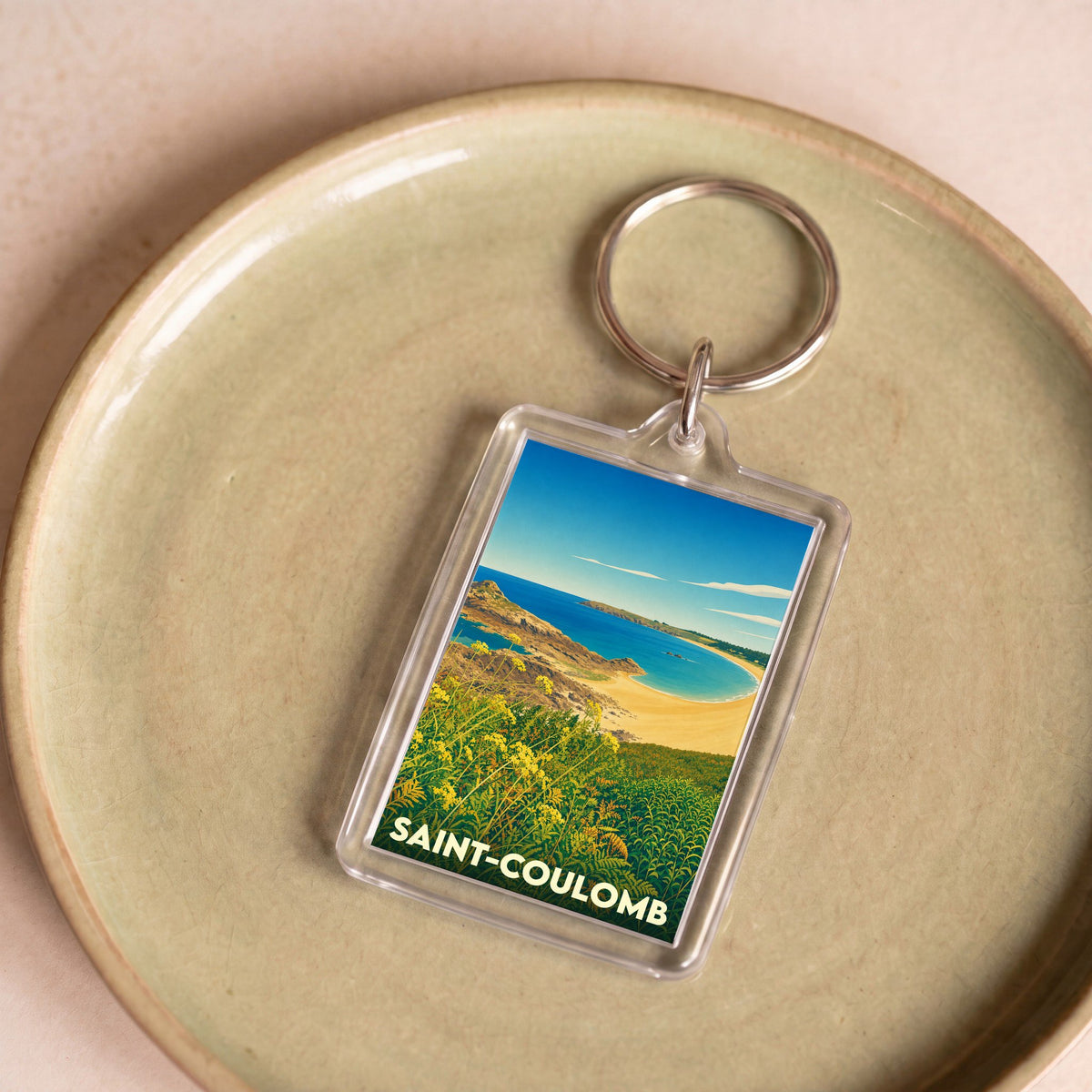 Porte-clés souvenir de la ville de Saint-Coulomb avec une illustration stylisée de sa côte.