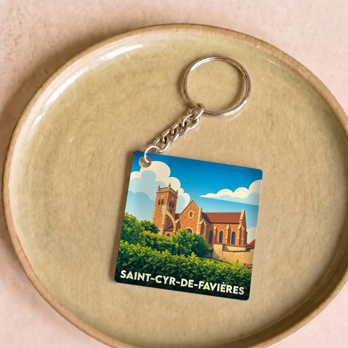 Porte-clés souvenir de la ville de Saint-Cyr-de-Favières avec une illustration stylisée de son église.