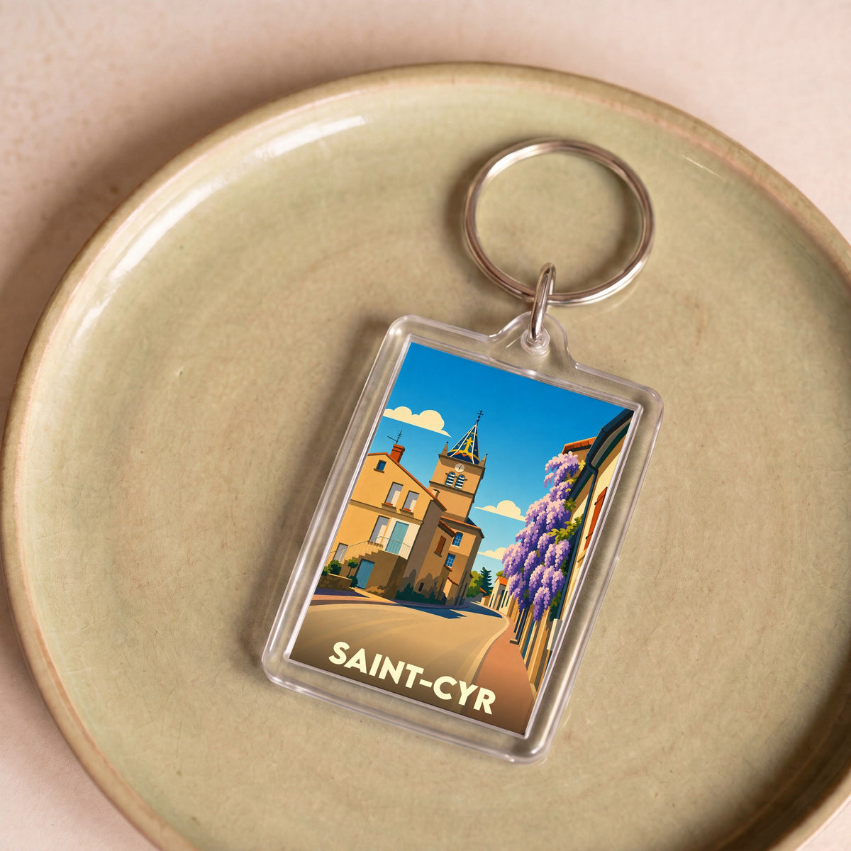 Porte-clés souvenir de la ville de Saint-Cyr avec une illustration stylisée.