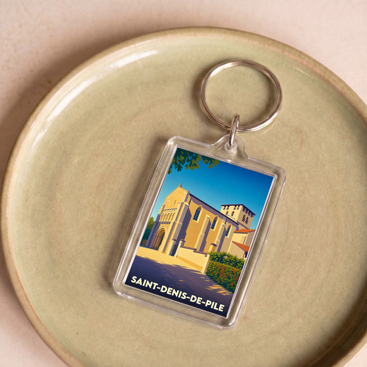 Porte-clés souvenir de la ville de Saint-Denis-de-Pile avec une illustration stylisée de son église.