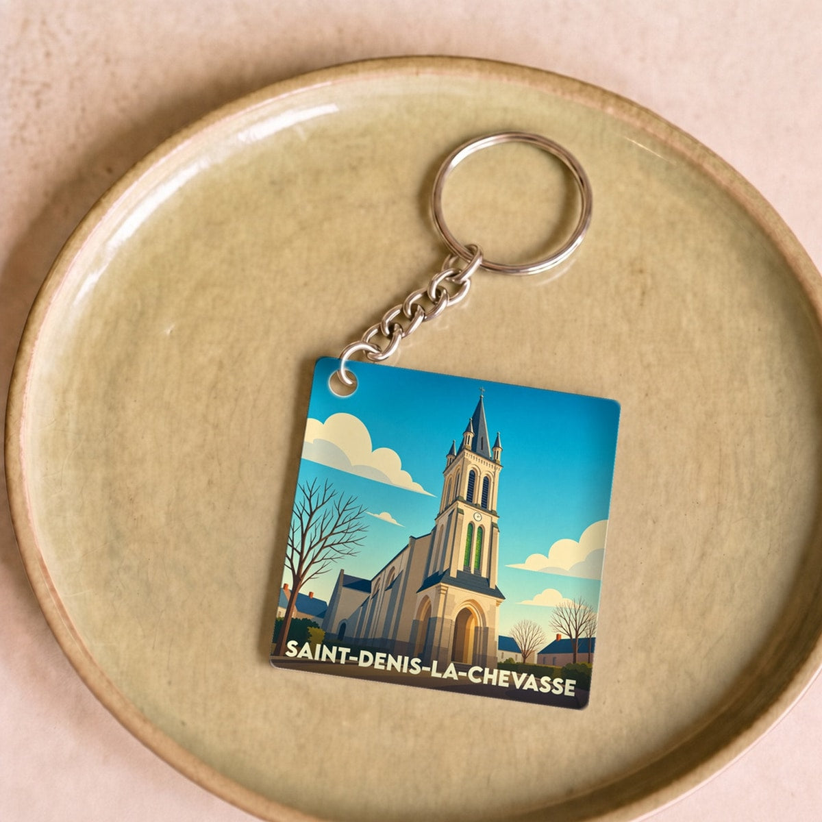 Porte-clés souvenir de la ville de Saint-Denis-la-Chevasse avec une illustration stylisée de son église.