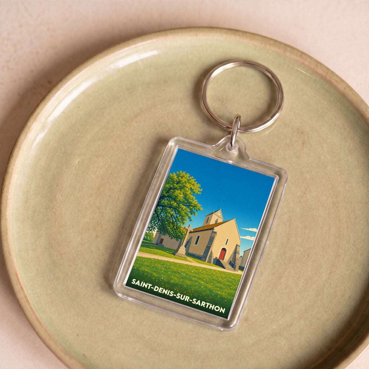 Porte-clés souvenir de la ville de Saint-Denis-sur-Sarthon avec une illustration stylisée de son église.