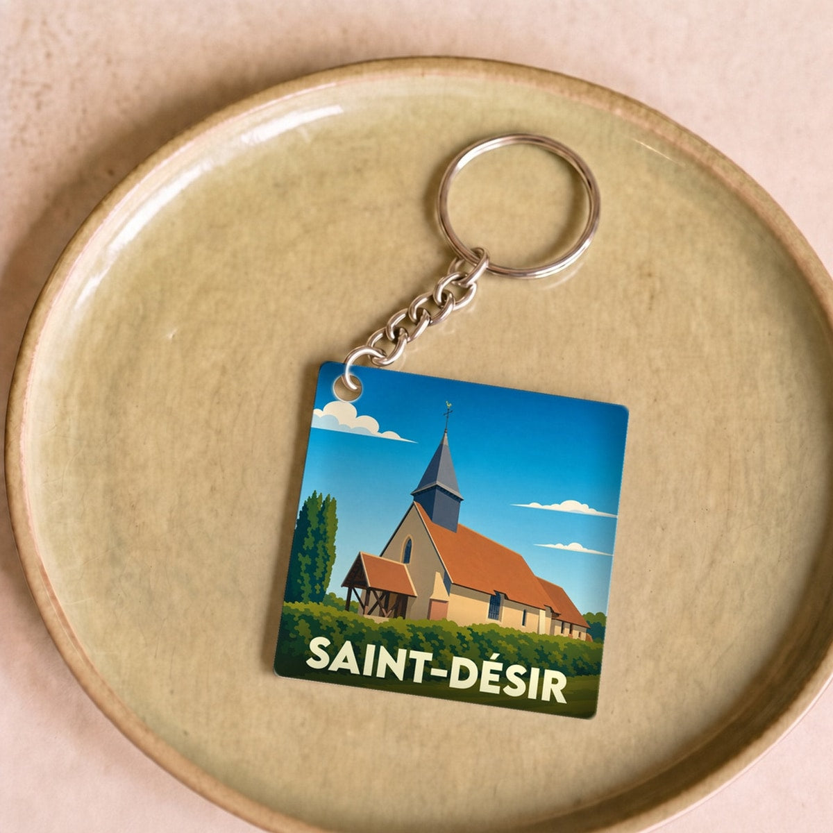 Porte-clés souvenir de la ville de Saint-Désir avec une illustration stylisée de son église.