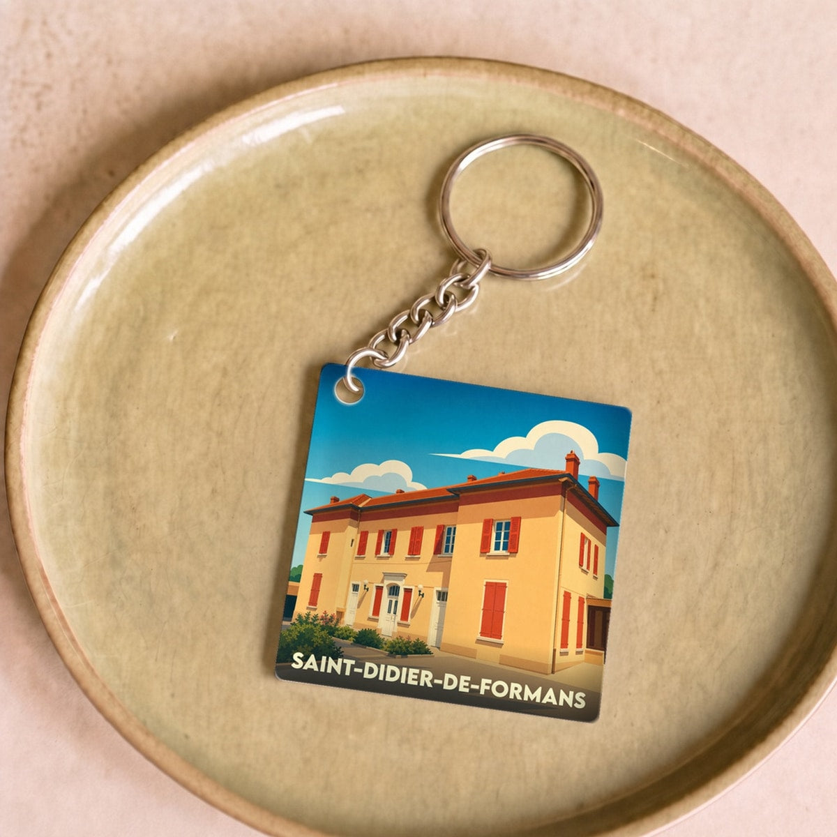 Porte-clés souvenir de la ville de Saint-Didier-de-Formans avec une illustration stylisée.