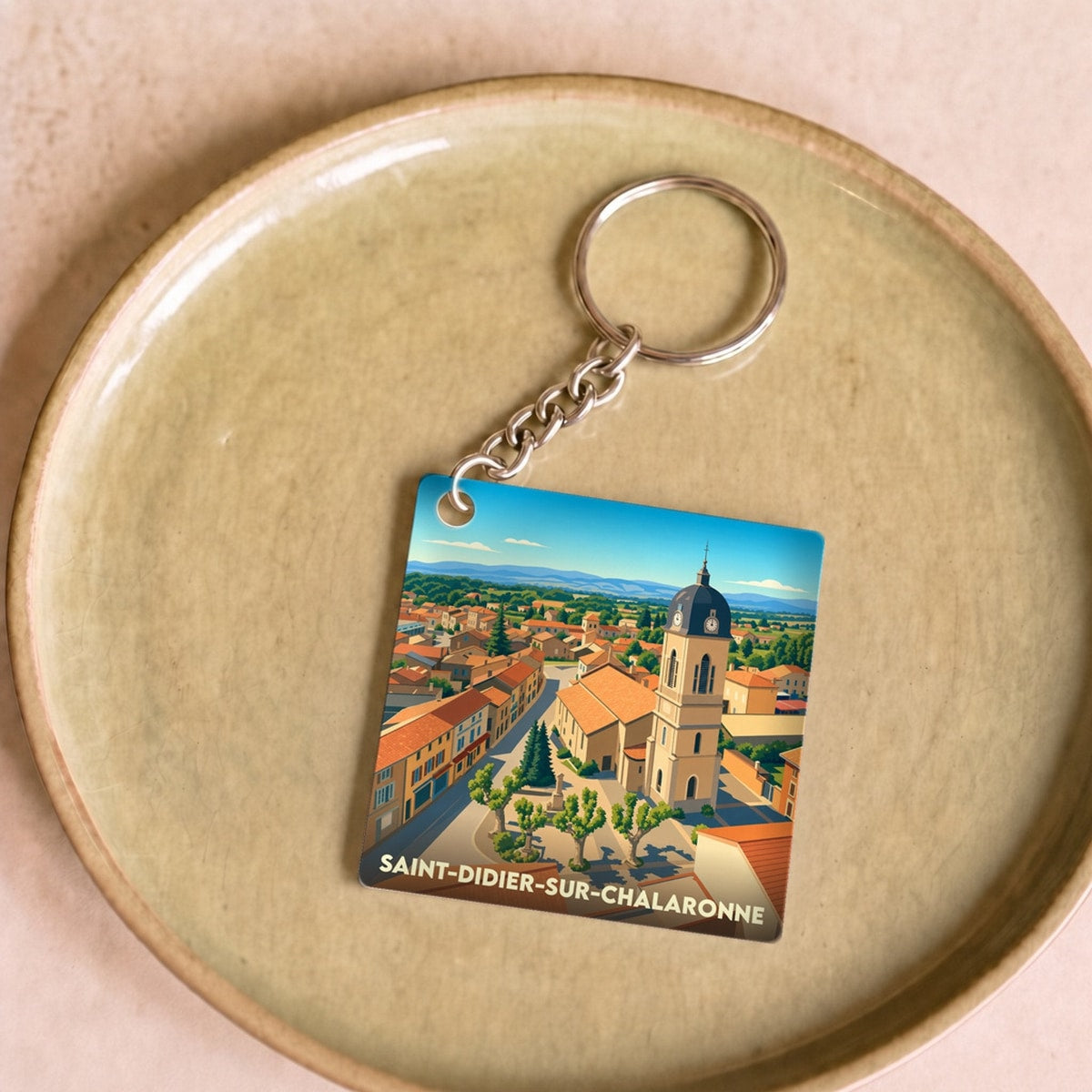 Porte-clés souvenir de la ville de Saint-Didier-sur-Chalaronne avec une illustration stylisée.