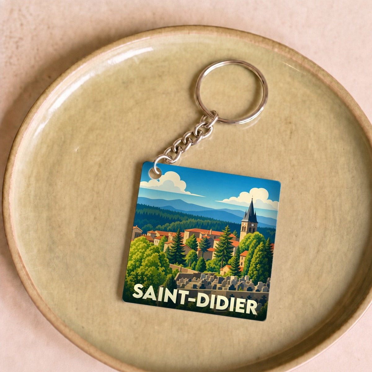 Porte-clés souvenir de la ville de Saint-Didier avec une illustration stylisée.