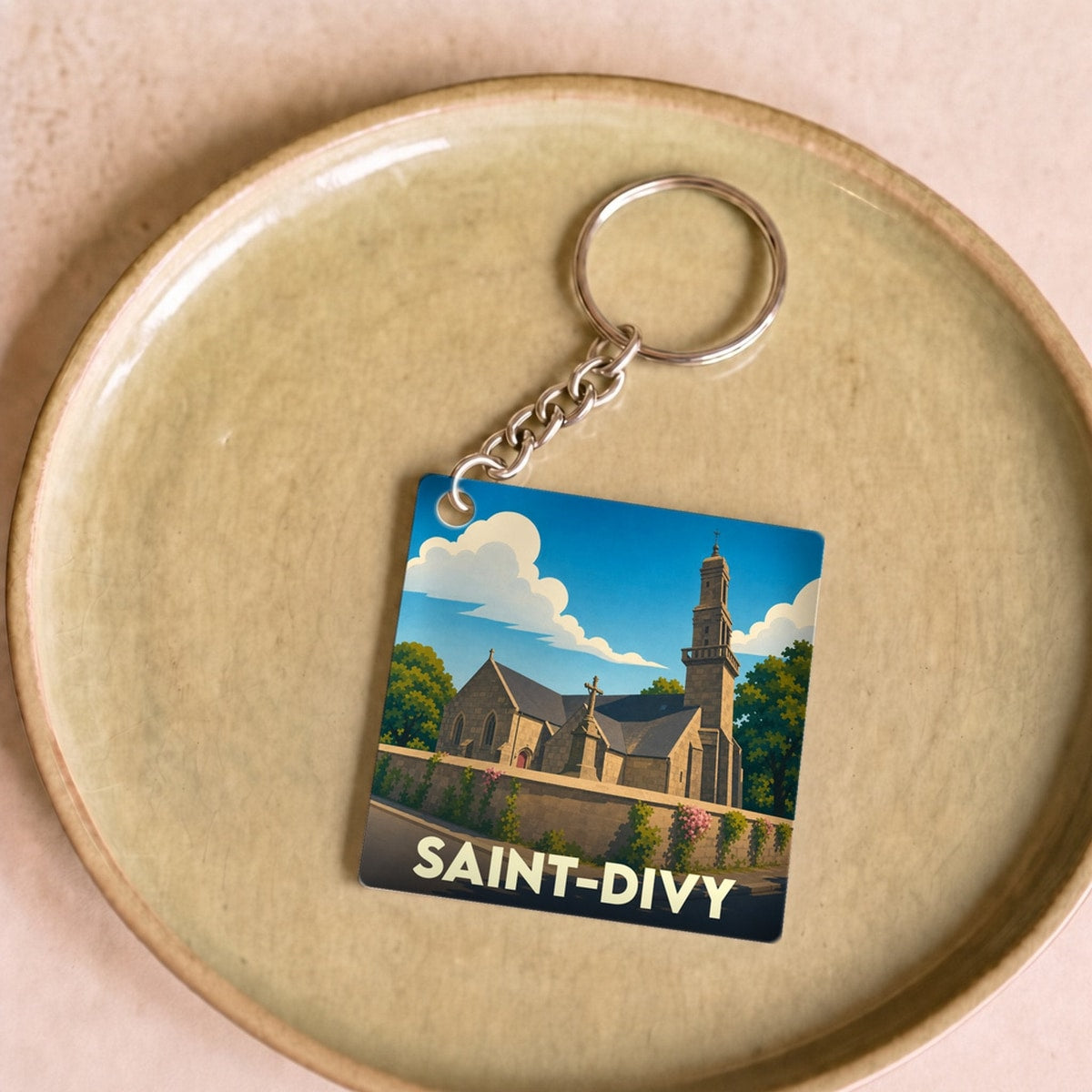 Porte-clés souvenir de la ville de Saint-Divy avec une illustration stylisée de son église.