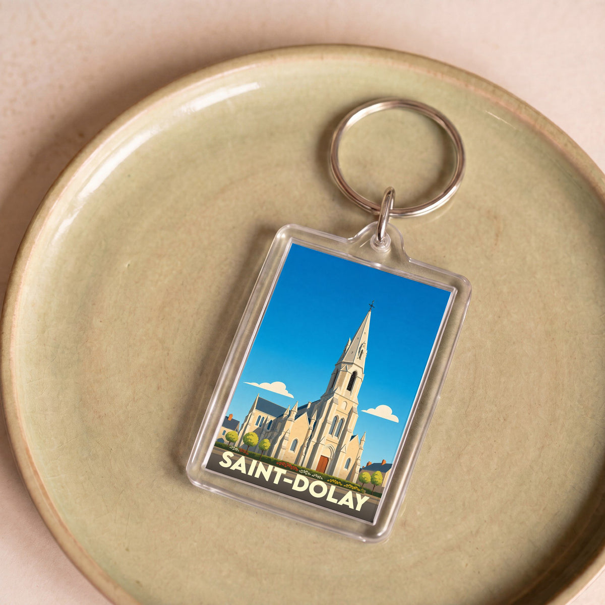 Porte-clés souvenir de la ville de Saint-Dolay avec une illustration stylisée de son église.