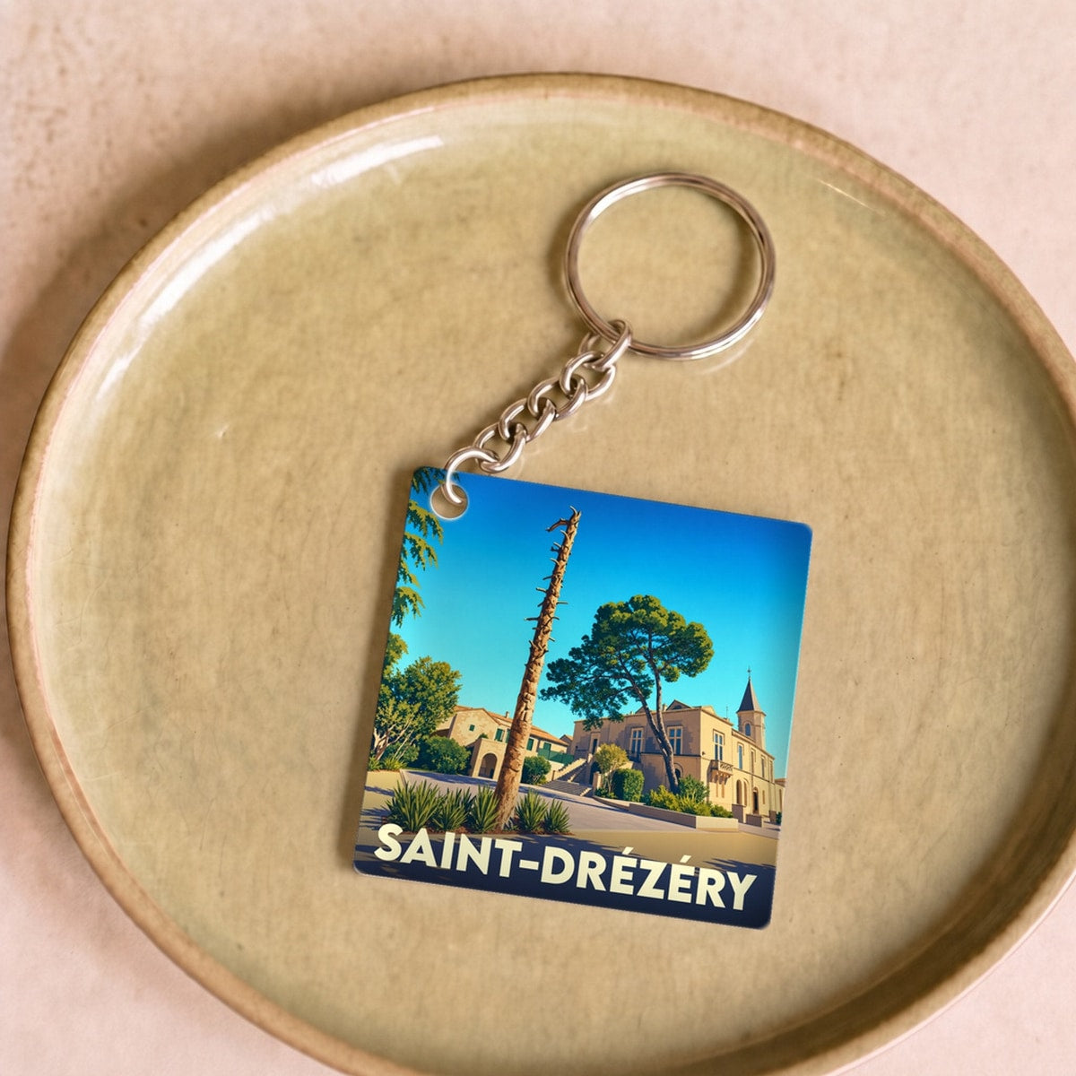 Porte-clés souvenir de la ville de Saint-Drézéry avec une illustration stylisée.