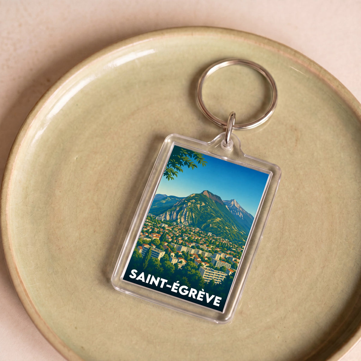 Porte-clés souvenir de la ville de Saint-Égrève avec une illustration stylisée de son paysage.