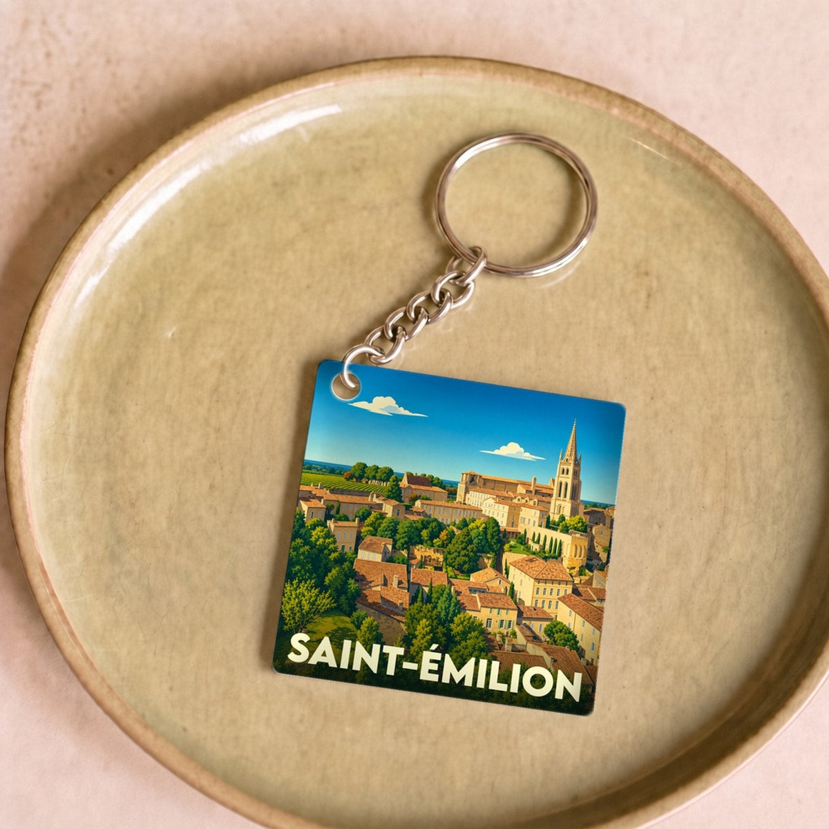Porte-clés souvenir de la ville de Saint-Émilion avec une illustration stylisée.