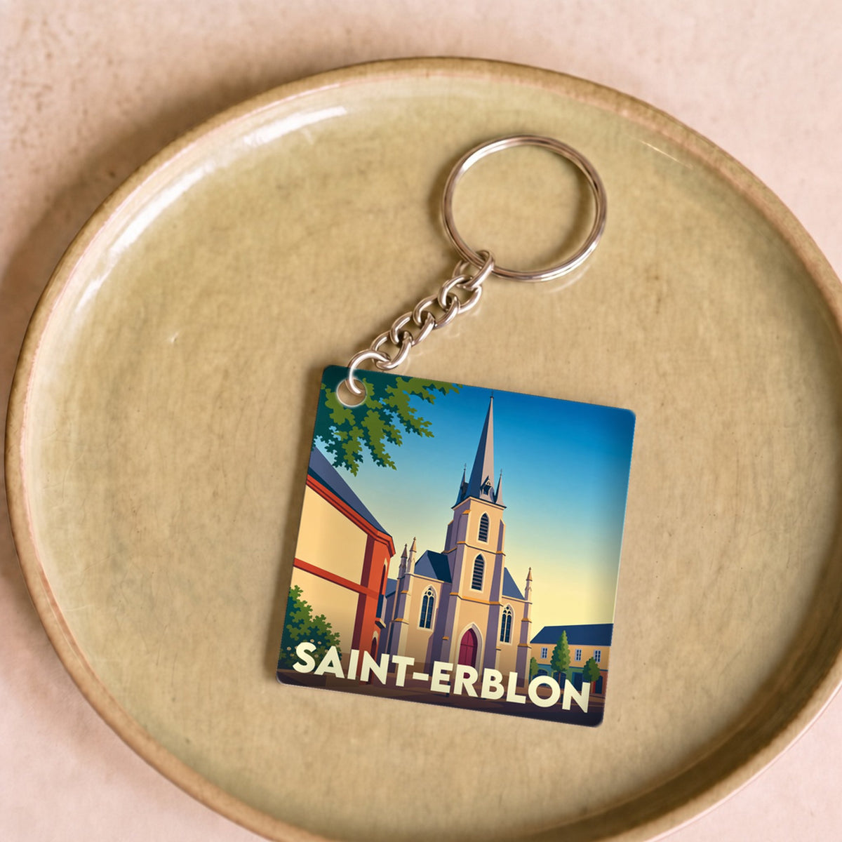 Porte-clés souvenir de la ville de Saint-Erblon avec une illustration stylisée de son église.