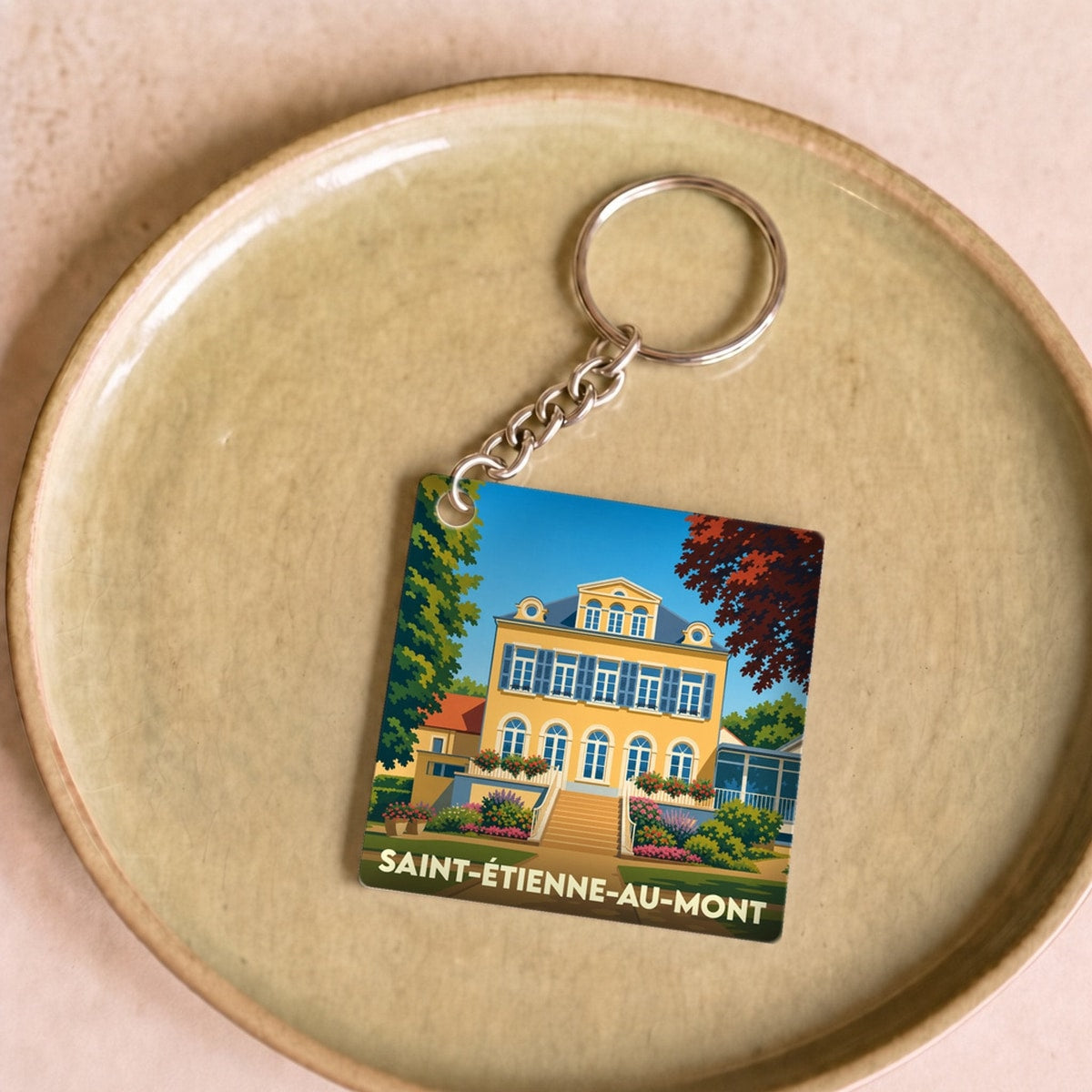 Porte-clés souvenir de la ville de Saint-Étienne-au-Mont avec une illustration stylisée.