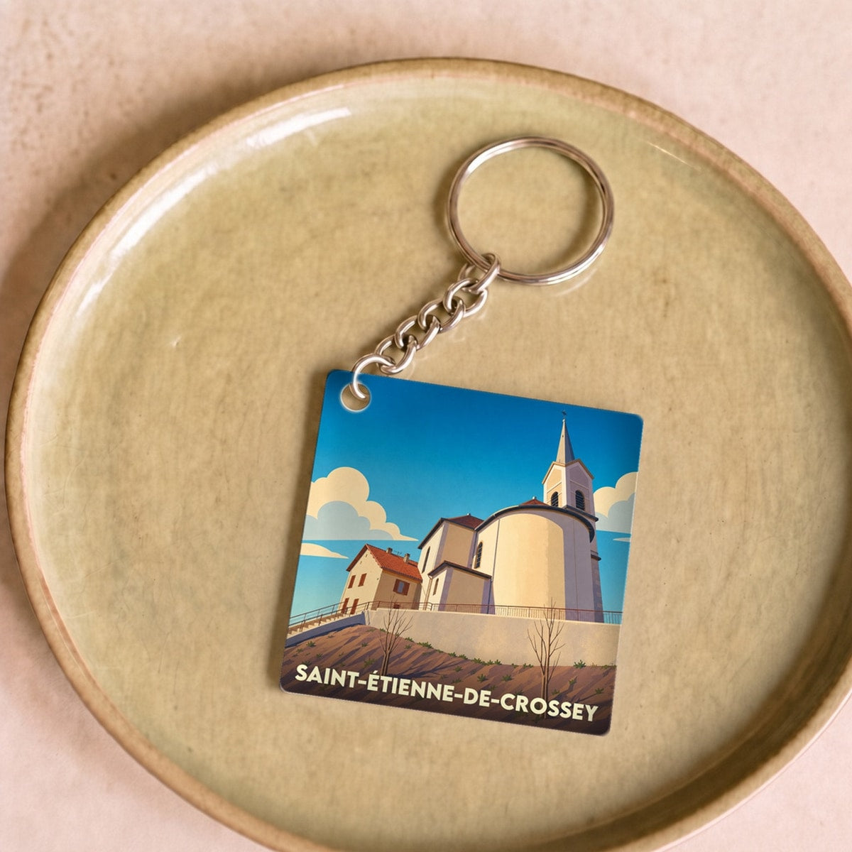 Porte-clés souvenir de la ville de Saint-Étienne-de-Crossey avec une illustration stylisée de son église.